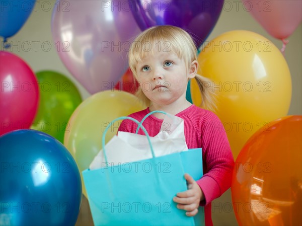 Portrait of baby girl (18-23 months) wit colorful balloons. Photo : Jessica Peterson