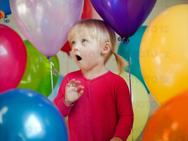 Portrait of baby girl (18-23 months) wit colorful balloons. Photo : Jessica Peterson