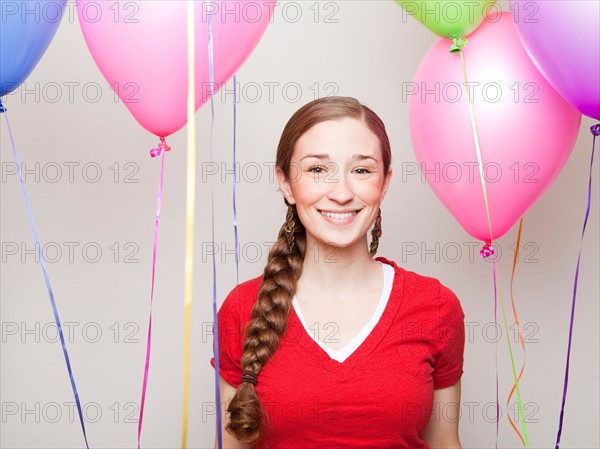 Studio Shot of young woman holding balloons. Photo : Jessica Peterson