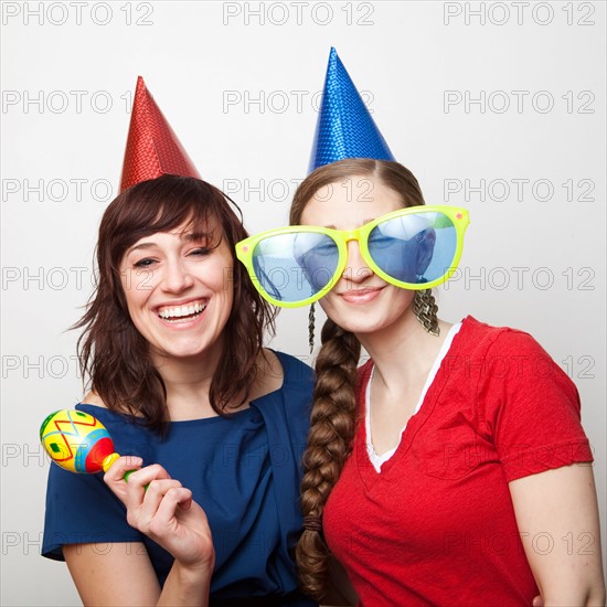 Studio Shot of young women dressed in party hat. Photo : Jessica Peterson