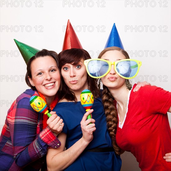 Studio Shot of young women dressed in party hat. Photo : Jessica Peterson