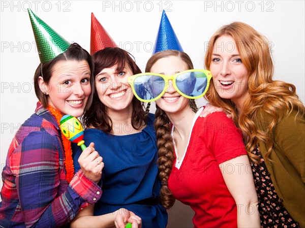 Studio Shot of young women dressed in party hat. Photo : Jessica Peterson