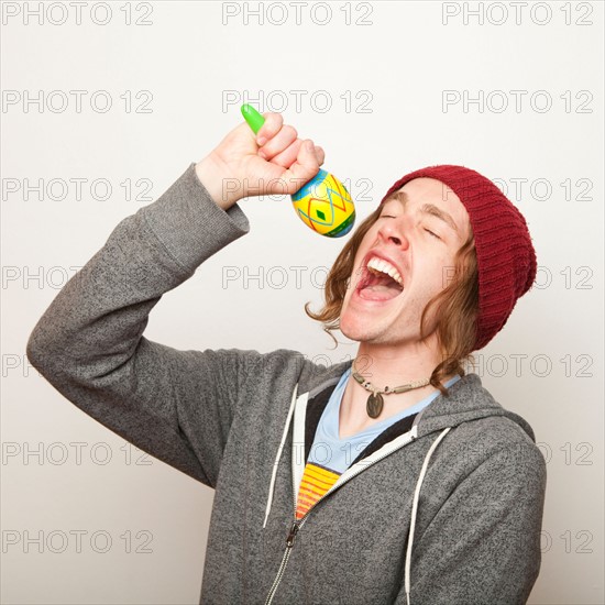 Studio Shot of young man pretending to sing. Photo : Jessica Peterson