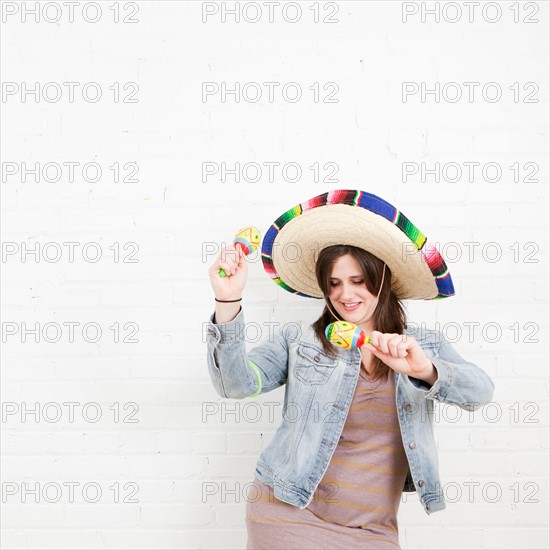 Studio Shot of young woman dancing in sombrero. Photo : Jessica Peterson