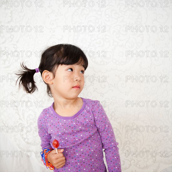 Studio Shot portrait of girl with lollipop (4-5). Photo : Jessica Peterson