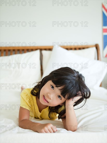 Portrait of girl lying down in bed (4-5). Photo : Jessica Peterson