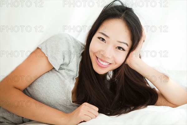 Portrait of young woman lying on side with hand on chin. Photo : Jessica Peterson