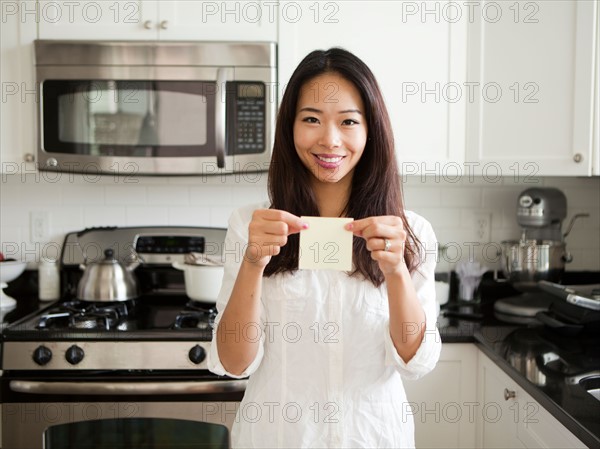 Portrait of young woman holding adhesive note . Photo : Jessica Peterson