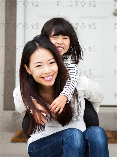 Smiling woman embracing by her daughter (4-5). Photo : Jessica Peterson