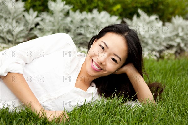 View of smiling woman lying on lawn. Photo : Jessica Peterson