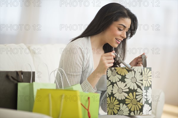 Young woman looking into shopping bag.