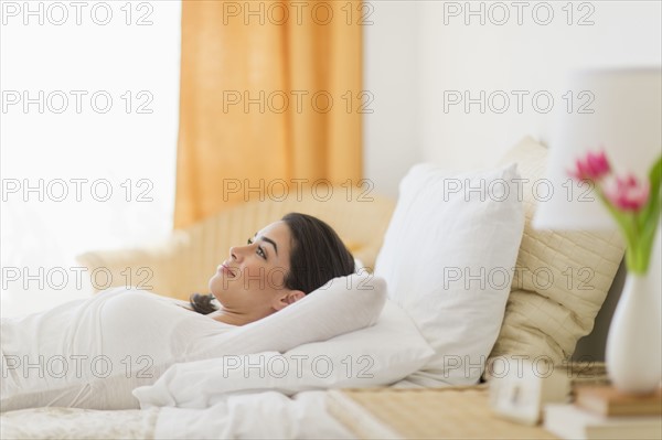 Young woman lying on bed.