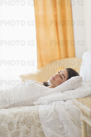 Young woman lying on bed.
