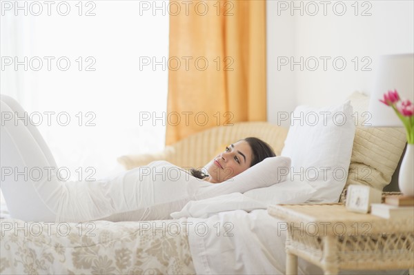 Young woman lying on bed.