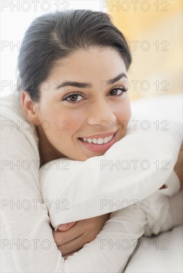 Portrait of young woman lying in bed.