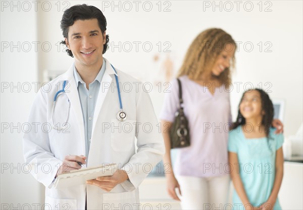 Doctor with patients (woman and girl aged 12-13) in office.