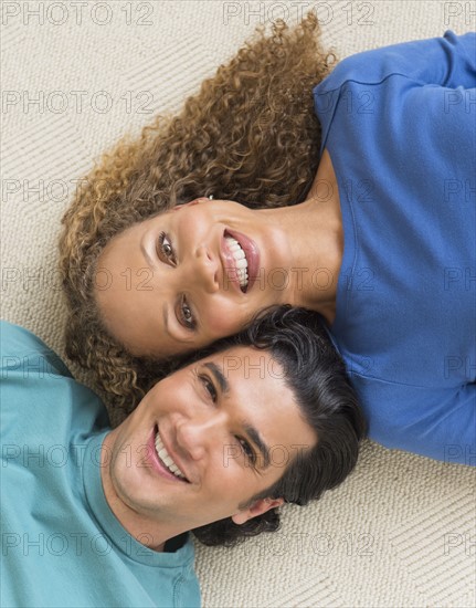 Portrait of couple lying on floor.