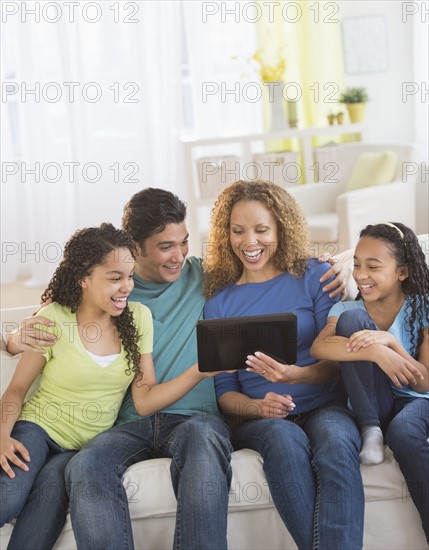 Parents with daughters (10-13) using tablet pc.