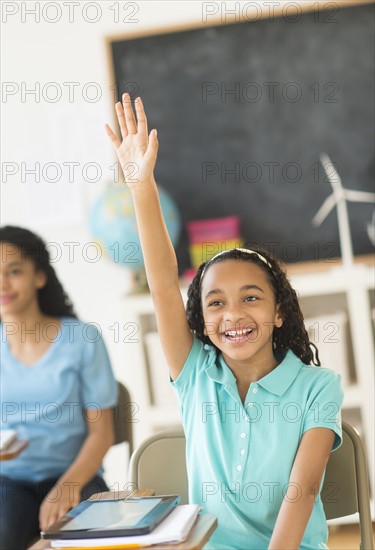 Schoolgirl (10-13) raising hand.