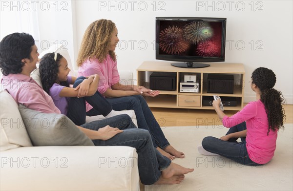 Parents with daughters (10-13) watching tv.