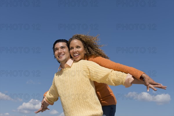 Couple under blue sky.