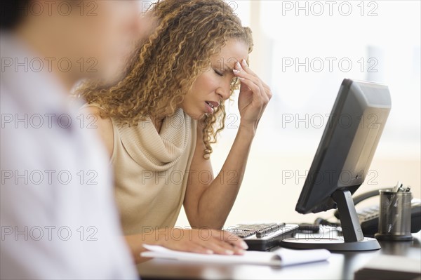 Business woman having headache in office.