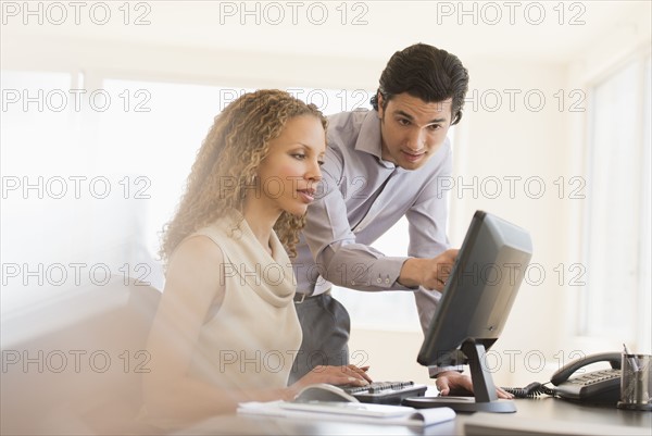 Business man and woman looking at computer.