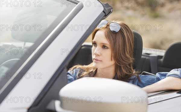 Young woman driving convertible.