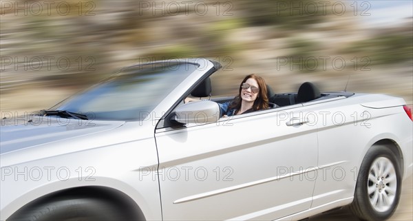 USA, California, Joshua Tree National Park, Young woman driving convertible.