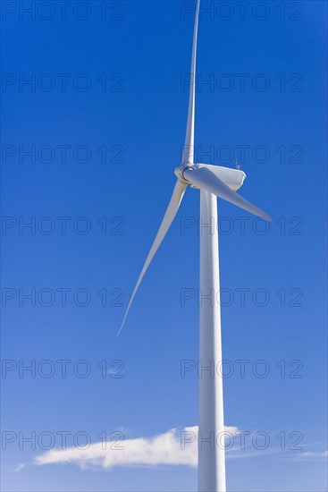 Wind turbine against blue sky.