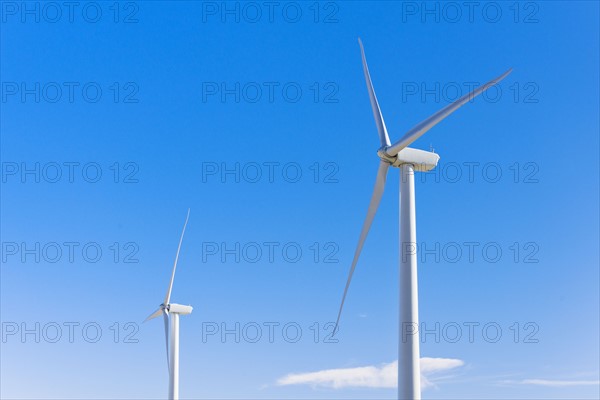 Wind turbines against blue sky.