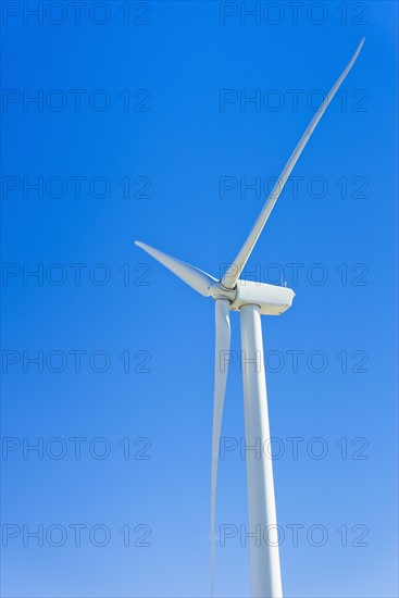 Wind turbine against blue sky.