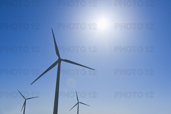 Wind turbine against blue sky.