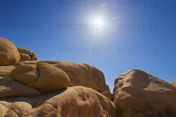 USA, California, Joshua Tree National Park, Desert rocks with solar flare.