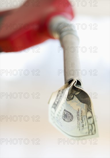 Fuel nozzle with dollar bill.