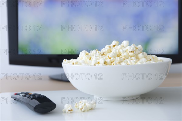 Television set and bowl of popcorn.