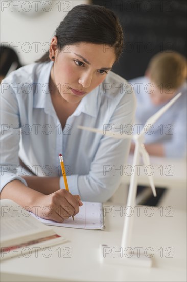 Female student examining wind turbine.