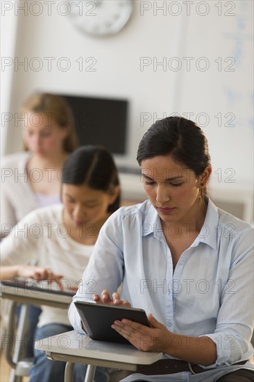 Students (14-19) using digital tablets.