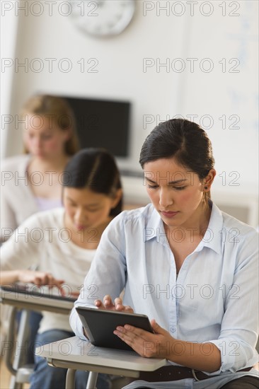 Students (14-19) using digital tablets.