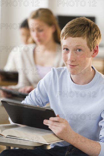 Students (14-17) using digital tablets at school.