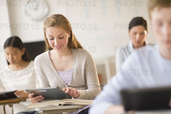 Students (14-19) using digital tablets at school.