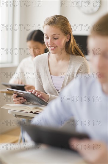 Students (14-17) using digital tablets at school.