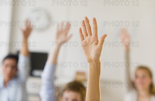 Students (14-19) raising hands.