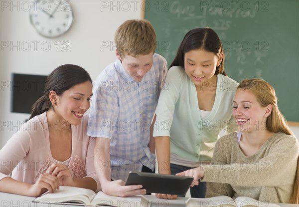 Students (14-19) using tablet pc in classroom.