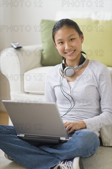 Portrait of girl (14-15) using laptop at home.