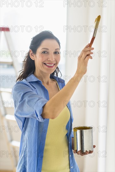 Woman painting wall at home.