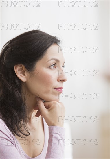 Woman with hand on chin.