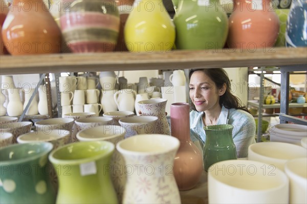 Female artist in pottery in studio.