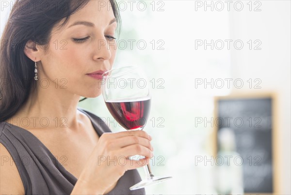 Woman tasting red wine.