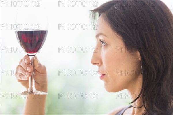 Woman tasting red wine.